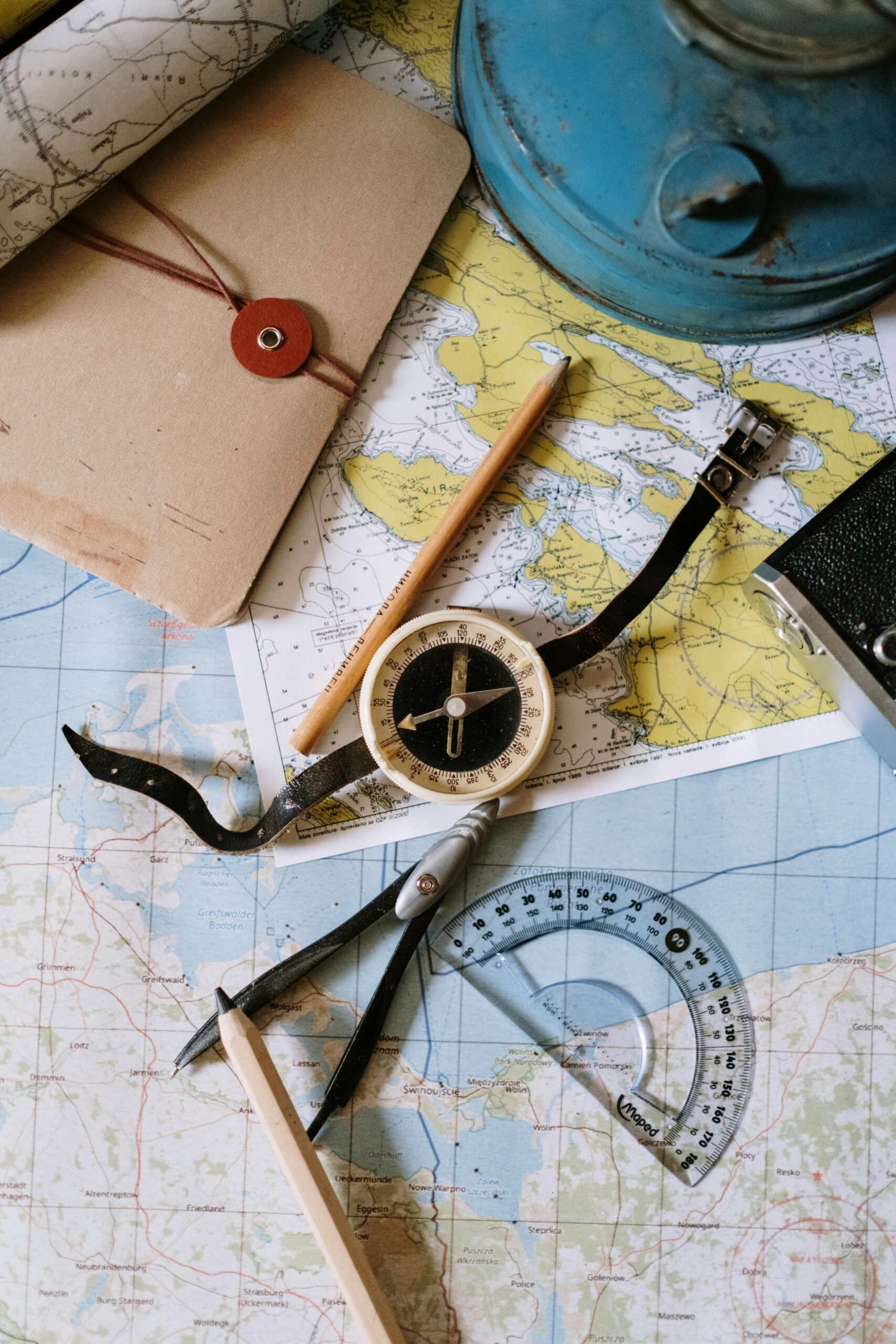 White and Black Compass Beside a Pencil